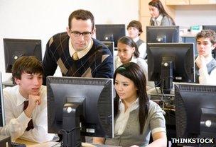 Teacher and teenage pupils in computer lab