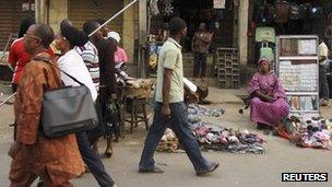 People walk past market stalls after the suspension of a nationwide strike by labour unions, in Nigeria's commercial capital Lagos, 16 January 2012