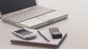 A laptop, mobile phone and notepad
