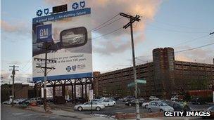 An advertisement for General Motors is displayed near the company's headquarters in Detroit, Michigan