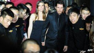 Christian Bale and his wife Sibu are escorted by Chinese security guards at the Flowers of War premiere in Beijing, December 12 2011