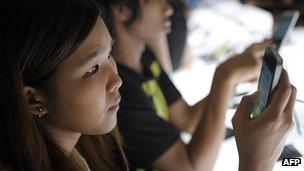 Customer looks at smartphone in Bangkok, Thailand