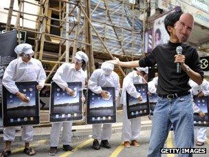 Protester in a Steve Jobs mask takes part in a demonstration against factory conditions in China