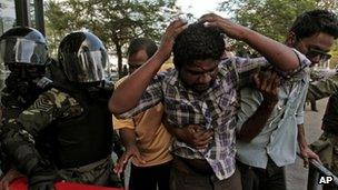 Supporters of former Maldivian President Mohamed Nasheed help a wounded protester as soldiers man a barricade near Republic Square in Male, Maldives, Wednesday, Feb. 8, 2012.