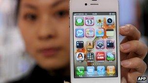 A woman holds her iPhone 4 in Hangzou, China 13 January 2012