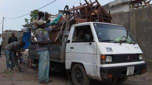 Congolese people load up furniture onto the back of lorries after a series of explosions rocked the capital Brazzaville on 4 March 2012