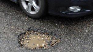 Car beside pothole