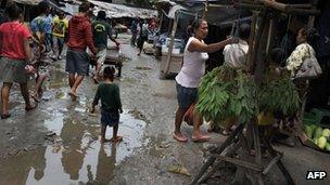 A child walks in a mud puddle at Dili's traditional market on March 15, 2012