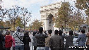 Chinese tourists taking photos of the Arc de Triomphe in Paris