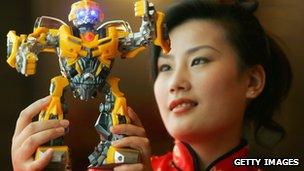 A model in Shanghai holds up a model of Bumble Bee a character from the US movie Transformers.
