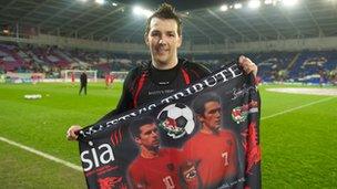 Matt Jones holds up a flag paying tribute to Gary Speed prior to Wales' home friendly against Costa Rica