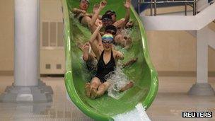 North Korean students ride down a water slide into a swimming pool at Kim Il-sung University in Pyongyang (April 11, 2012)