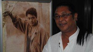 Actor and director Kyaw Thu in front of a picture of himself during his acting heyday.