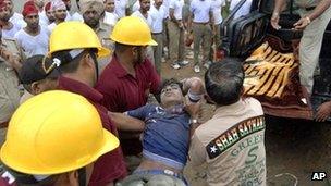 Rescuers remove a worker from the debris of a collapsed factory in Jalandhar on 16 April 2012
