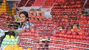An Indian fruit vendors waits for customers