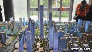 Investors looking at a model of Beijing's future skyline