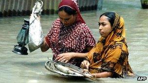 Bangladeshi wade through floodwaters