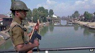 An Indian paramilitary soldier stands guard on a bridge on the Jhelum river in central Srinagar.