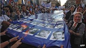 Members of the Madres de Plaza de Mayo hold, with hundreds of people, a large flag with the portraits of the disappeared during the last dictatorship (1976-1983), March 2012