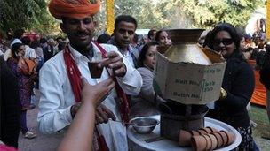 Vendor serves tea in earthen cups