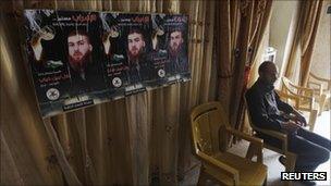 Bassam Diab sits next to posters depicting his brother, Bilal, at his home near the West Bank town of Jenin