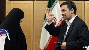 Iranian President Mahmoud Ahmadinejad waves after casting his ballot as his wife Azam Farahi looks on at a polling station for the parliamentary election run-off in Tehran on 4 May 2012.