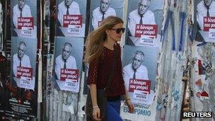 Woman walks past Greek election posters