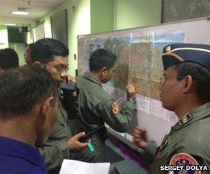 Indonesian officials plot the plane's movements on a map in Jakarta, 9 May (photo: Sergey Dolya)
