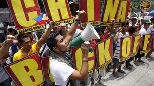 Activists chant and hold placards outside the Chinese embassy in Manila on 11 May 2012