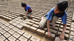 Children turning adobe bricks for drying in Huachipa, some 50 km east of Lima, in 2008