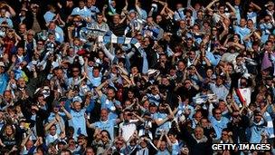 Manchester City fans celebrate their team's Premier League win in 2012