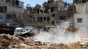 Workers clear debris left by the attack in Damascus on 10 May