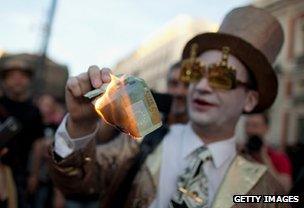 Protester burns a euro note