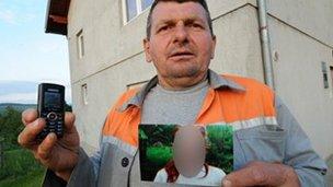 A neighbour holds the picture he took of a German girl allegedly enslaved by a couple in Bosnia