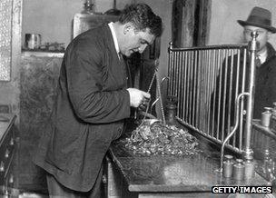 1932: Dealer examines gold articles bought from the public, after lifting of the Gold Standard in Britain led to hundreds of thousands of pounds worth of gold being sold