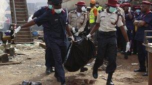 Rescue workers carry bodies at the site of a plane crash in Lagos, Nigeria, Monday, 4 June 2012