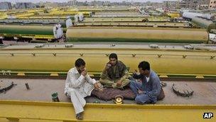 Pakistani drivers drink tea on top of an oil tanker, which was used to transport Nato fuel supplies to Afghanistan but is now parked with other tankers in a compound in Karachi. June 4 2012