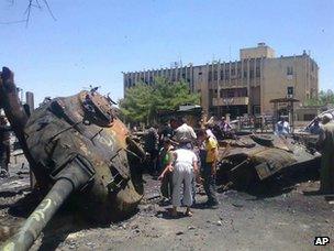 Locals inspect the remains of a destroyed Syrian army tank in the town of Ariha (4 June 2012)