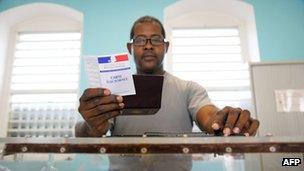 A scrutineer checks the electoral card of an overseas voter before the vote in the first round of the 2012 French parliamentary elections