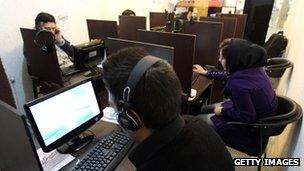 People sitting in front of computers in an internet cafe in Tehran