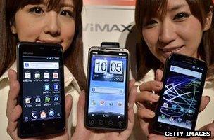 Models hold up Android-based smartphones