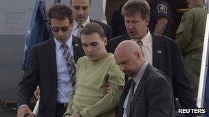 Luka Rocco Magnotta is escorted off a plane in Mirabe by police