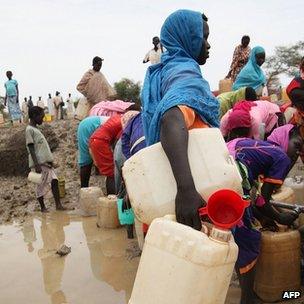 People gathering water at a man-made water hole, in South Sudan's Upper Nile state