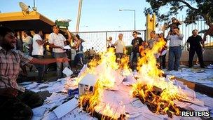 Protesters burn ballot papers and other election materials outside the High National Election Commission's office in Benghazi on 1 July 2012