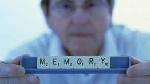 Man holding up scrabble words spelling memory