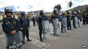 Riot policemen stand guard as thousands of residents march in Cajamarca on 29 May, 2012