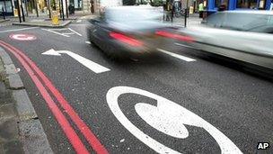 Cars drive pass congestion charge signs