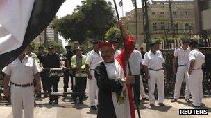 A supporter of President Mohammed Mursi wears and carries an Egyptian flag in front of the parliament building in Cairo