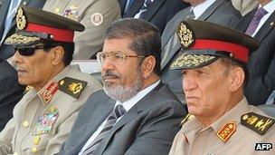 The head of Scaf, Field Marshal Mohammed Hussein Tantawi, President Mohammed Morsi and army chief of staff Gen Sami Enan sit together