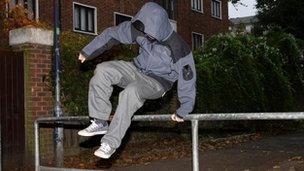 A teenage boy jumping over a barrier